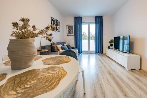 a living room with a couch and a tv at Glow Apartments, Apartamenty Nowa Letnica in Gdańsk