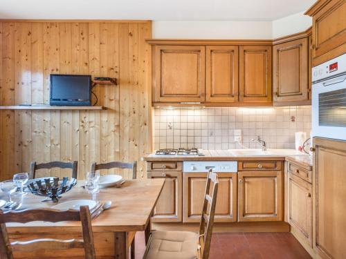 une cuisine avec une table en bois et une table et des chaises dans l'établissement Charmant appart T3 pour 4 pers, proche pistes, centre et sports - Balcon Sud/Est, animaux OK - FR-1-453-80, à Megève
