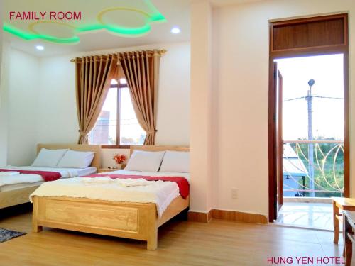 two beds in a room with a window at Khách Sạn Hưng Yên in Phu Quoc