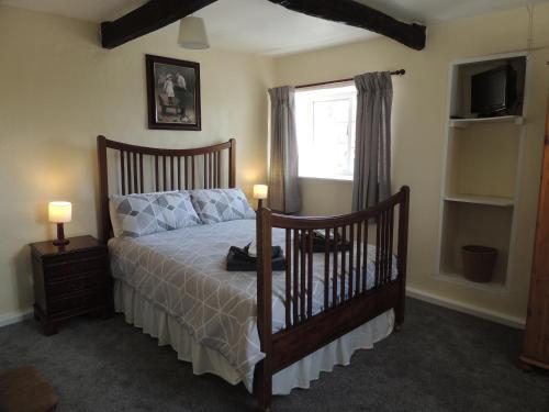 a bedroom with a bed and a window at The Cottage on the Green in Winkleigh