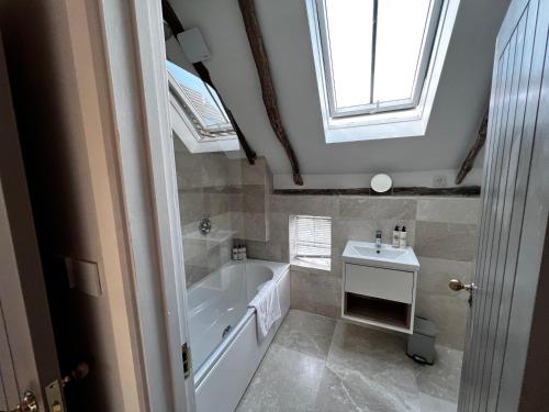 a bathroom with a bath tub and a sink at Seven Abbey Lane in Southam