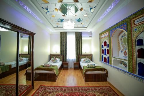 a room with two beds and a mirror at Hotel "RAYHON" in Bukhara