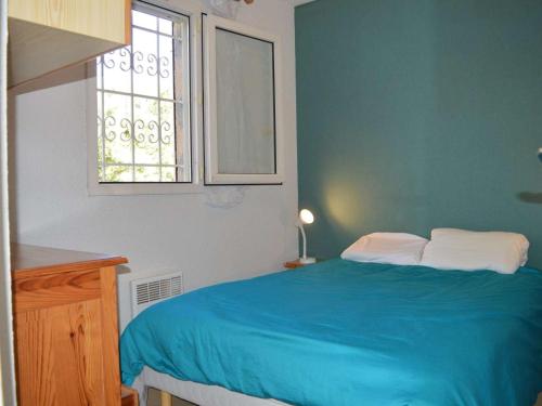 Un dormitorio con una cama azul y una ventana en Appartement La Croix-Valmer, 2 pièces, 4 personnes - FR-1-226B-28, en La Croix-Valmer