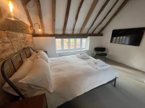 a bedroom with a large white bed in a room at Seven Abbey Lane in Southam