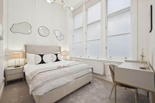 a white bedroom with a large bed and a desk at (G4) Luxurious 2 Bed Blythswood Flat in Glasgow