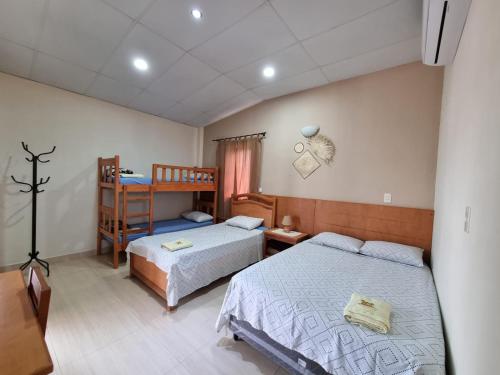 een slaapkamer met 2 bedden en een stapelbed bij Hotel Karanda´y in Villa Concepción