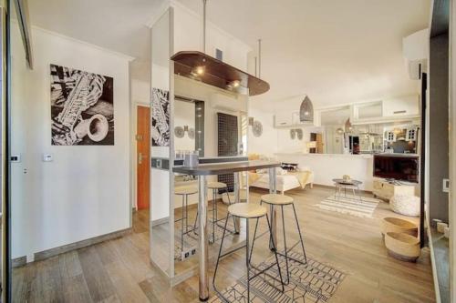 - une cuisine et un salon avec une table et des tabourets dans l'établissement Beautiful 28m2 studio with balcony, à Cannes