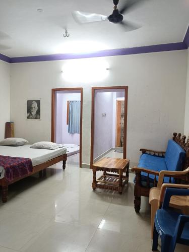 a bedroom with a bed and a table and a mirror at Full Moon House Tiruvannamalai in Tiruvannāmalai