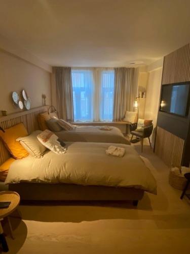 a hotel room with two beds and a television at Maison de ville - 4 personnes - Ô coeur de Spa in Spa