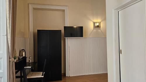 a room with a black cabinet with a tv on it at Giardino Siciliano B&B in Catania