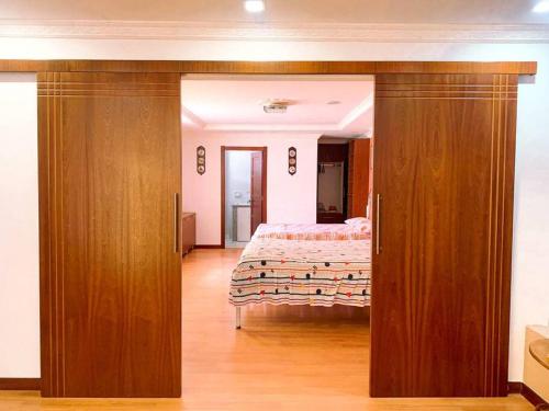 1 dormitorio con 1 cama y puerta de madera grande en Apartamento Loja Cómodo e Independiente, en Loja