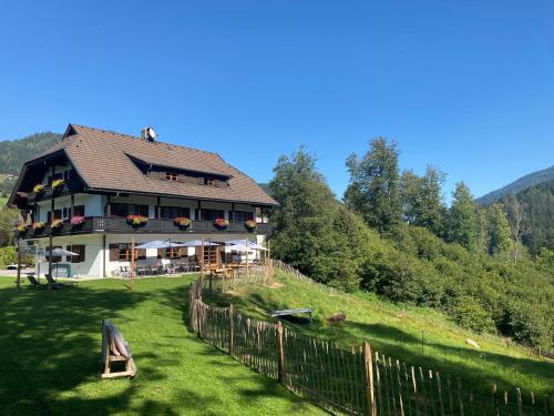 a large house on a hill with a fence at Gasthof Arriach in Arriach