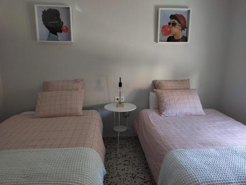 duas camas num quarto com uma mesa e duas fotografias em CASA ANTONIO Y GABI Ruta de los dinosaurios em Igea