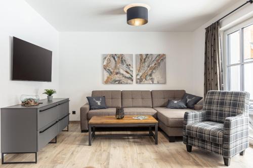 a living room with a couch and a chair at AlpiNest Feriendorf Lungau in Mariapfarr