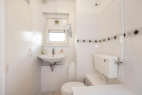 uma casa de banho branca com um WC e um lavatório em Easy living near Angel and City University em Londres