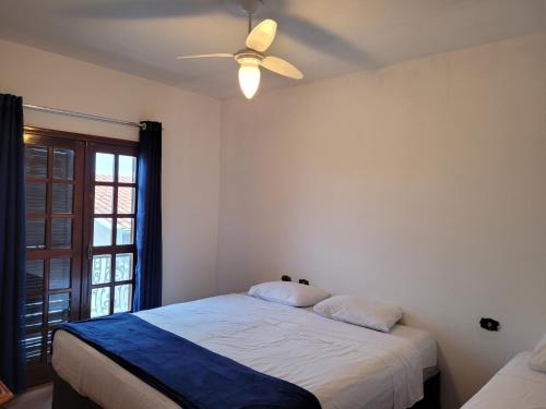 a bedroom with a bed and a ceiling fan at Hostel BoituVillage in Boituva