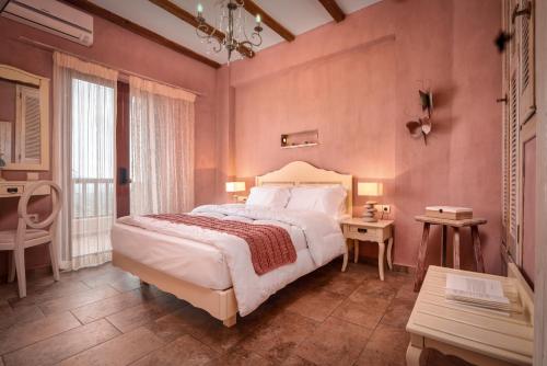 een slaapkamer met een groot bed in een roze kamer bij Amorosa Villas in Lagópodhon