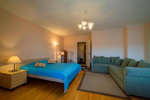 1 dormitorio con 1 cama azul y 1 sofá en Romeo Family Kaarli Apartment, en Tallin