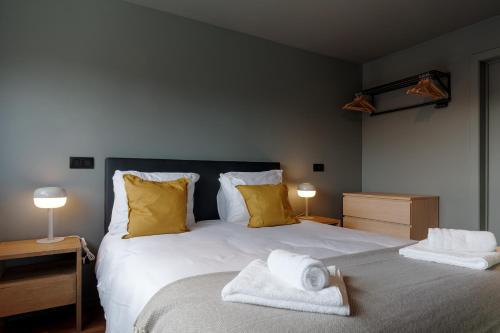 a bedroom with a large bed with towels on it at Spacious & Chic House in Center in Kortrijk