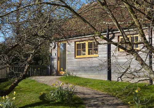 a white house with a door and a yard at The Squeak at Moor Farm in Godshill