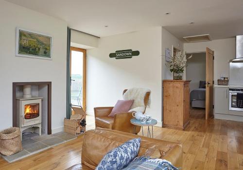 a living room with a couch and a fireplace at The Squeak at Moor Farm in Godshill