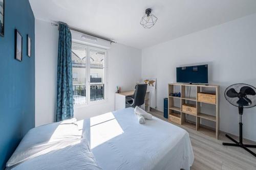 une chambre avec un lit, un bureau et une télévision dans l'établissement F2 Cozy Pour 4 Proche Disneyland - Fairytale Factory, à Villeneuve-Saint-Denis