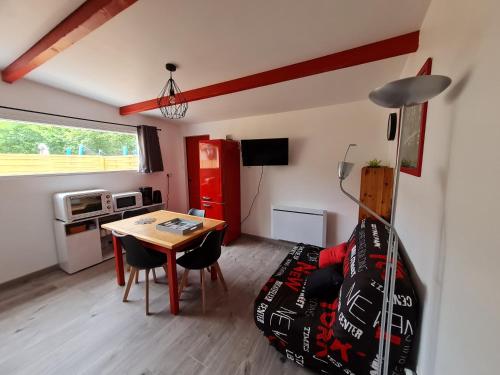 - un salon avec une table et un réfrigérateur rouge dans l'établissement Atelier des Rêves, à Smarves