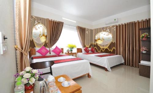 um quarto de hotel com duas camas e uma mesa em TAMCOC VUTHANH FRIENDLY Hotel em Ninh Binh