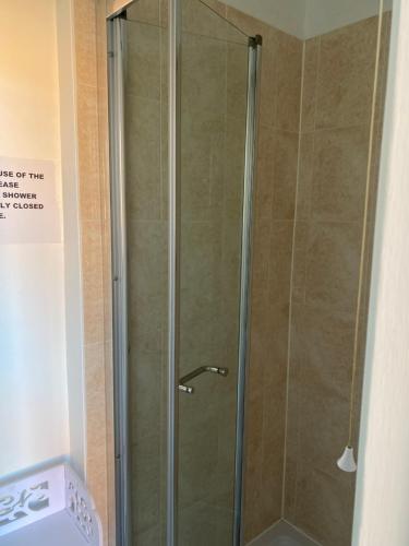 a shower with a glass door in a bathroom at The Ashville Bed and Breakfast in Bristol