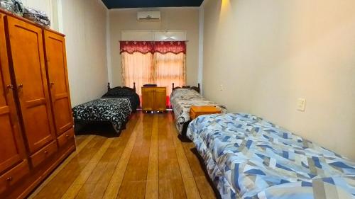 a room with two beds and a window at Lumay in Puerto Iguazú