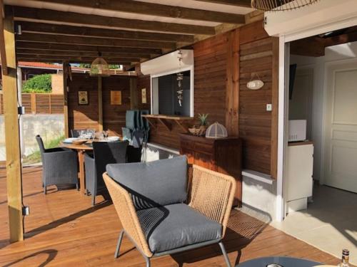 a patio with chairs and a table and a kitchen at Villa Tigo T3 Colibri in Sainte-Luce