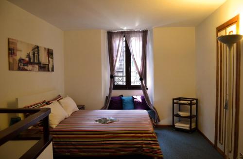 um pequeno quarto com uma cama e uma janela em Palazzo Velli em Roma