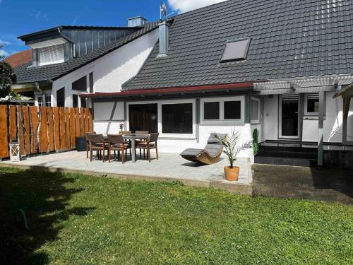 ein Haus mit einer Terrasse mit einem Tisch und Stühlen in der Unterkunft Franzis Landhaus in Singen