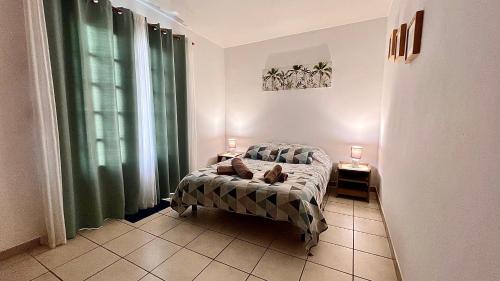 a bedroom with a bed and two lamps on two tables at Rev' Horizon in Le Tampon