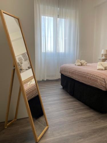 a mirror next to a bed in a bedroom at Exphome in Novate Milanese