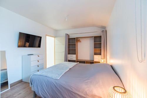 a white bedroom with a bed and a tv at Belle longère familiale - Trémuson in Trémuson