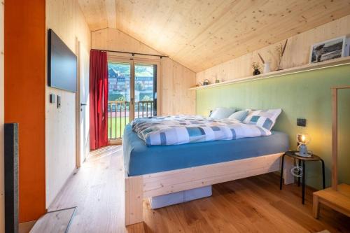 1 dormitorio con 1 cama en una habitación con ventana en The Swiss Bijou / Alpine Retreat, en Stans