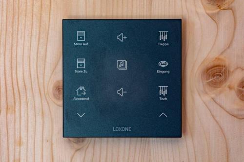 a remote control sitting on top of a wooden table at The Swiss Bijou / Alpine Retreat in Stans