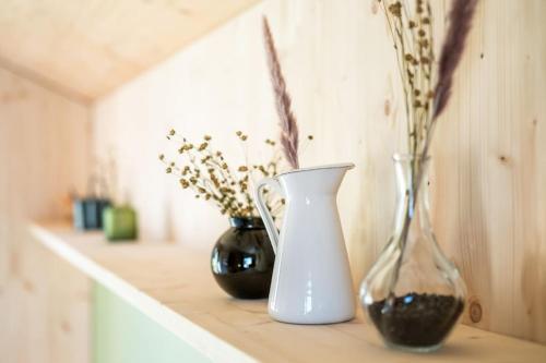 three vases sitting on a counter with flowers in them at The Swiss Bijou / Alpine Retreat in Stans
