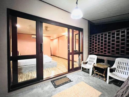 Habitación con cama, 2 sillas y espejo. en Haad Khuad Resort, en Bottle Beach