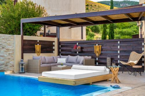a patio with a bed and a swimming pool at Amorosa Villas in Lagópodhon