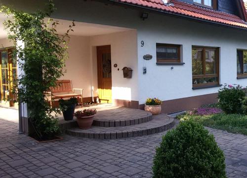a house with a brick patio with a bench on it at Komfort Ferienwohnung in Herscheid