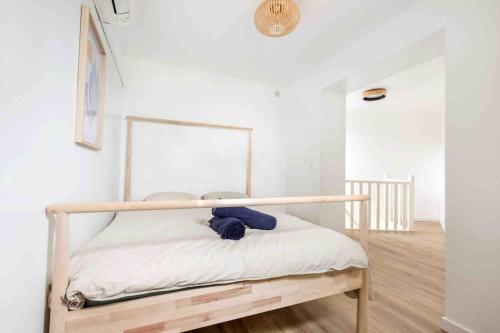 uma cama com uma estrutura de madeira num quarto em Appartement RDC Mairie de Marcq em Marcq-en-Baroeul