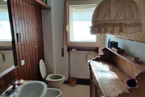 a bathroom with a sink and a toilet and a window at Casa Madesimo - Impianto sciistico e Parcheggio in Madesimo