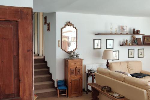 a living room with a couch and stairs with a mirror at Casa Madesimo - Impianto sciistico e Parcheggio in Madesimo
