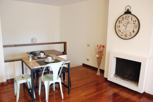 a dining room with a table and a clock on the wall at Palazzo Velli Suites in Rome