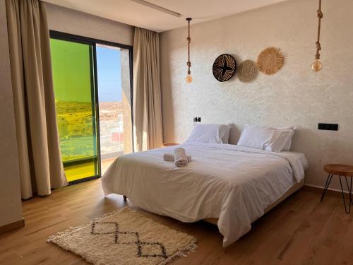 ein Schlafzimmer mit einem Bett und einem großen Fenster in der Unterkunft Beach Side Imsouane in Imsouane