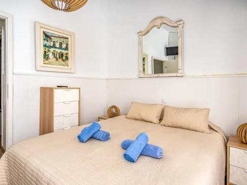 a bedroom with a bed with blue pillows on it at Chalet Baena Torremolinos in Torremolinos