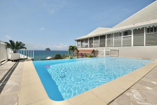 a swimming pool in front of a building at Cœur de Diams in Le Diamant