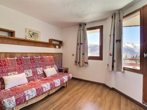 een slaapkamer met een bed en een raam met uitzicht op de bergen bij Appartement La Tania, 2 pièces, 6 personnes - FR-1-182A-11 in Courchevel